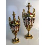 Two Royal Crown Derby Old Imari 1128 lidded two handled three part urns, one marked XL, both finials