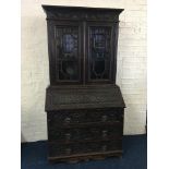 A 19th century heavily carved oak bureau bookcase with green man carved design. IMPORTANT: Online