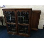 An oak lead glazed bookcase top together with an oak single glazed door book cabinet with cupboard