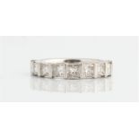 A diamond nine stone half eternity ring, bar set with nine princess cut diamonds, total diamond