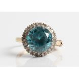 A blue zircon and diamond cluster ring, set with a central round cut blue zircon, measuring