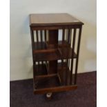 An Edwardian mahogany revolving bookcase with satinwood band inlay to top. IMPORTANT: Online viewing