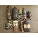 A selection of various wood carved tribal related items to include seven face masks and six wood