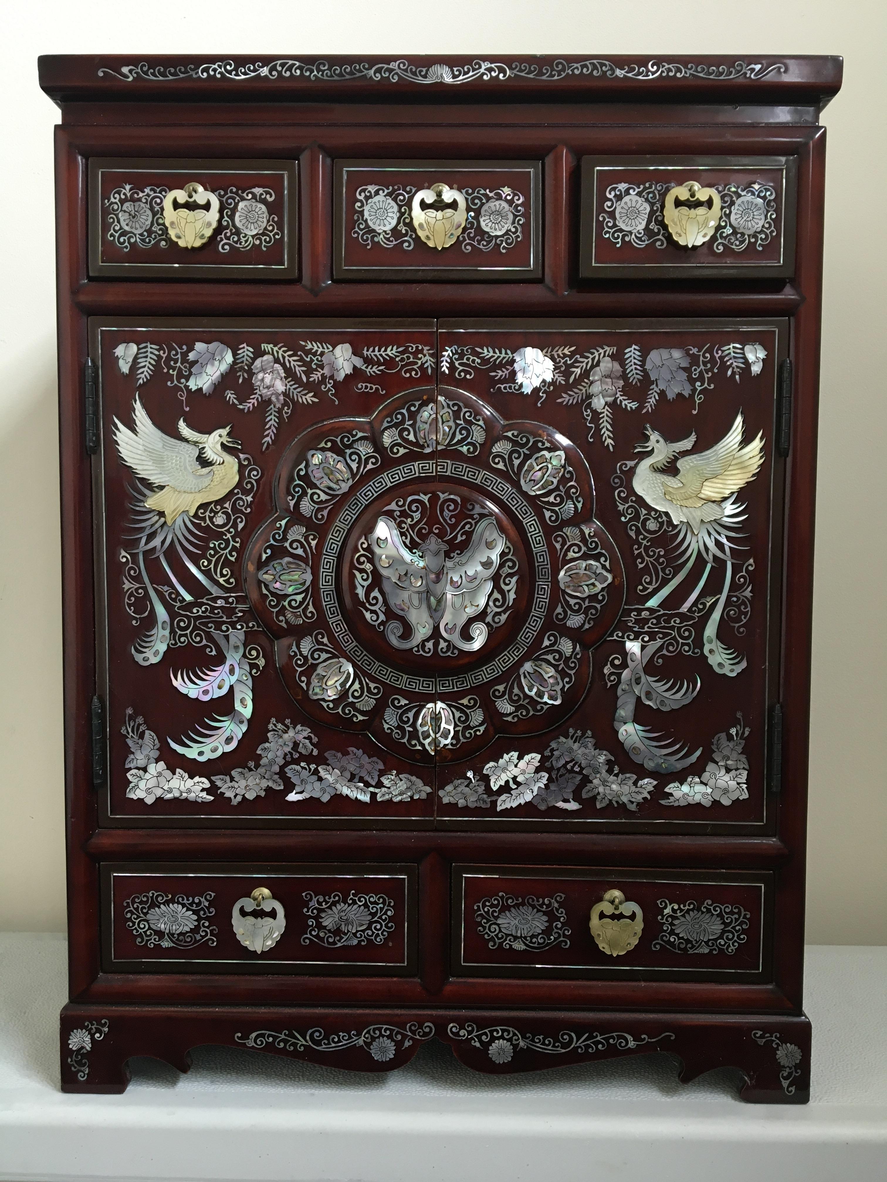 A Chinese lacquerware style jewellery box chest fitted to front with five drawers and two doors, two