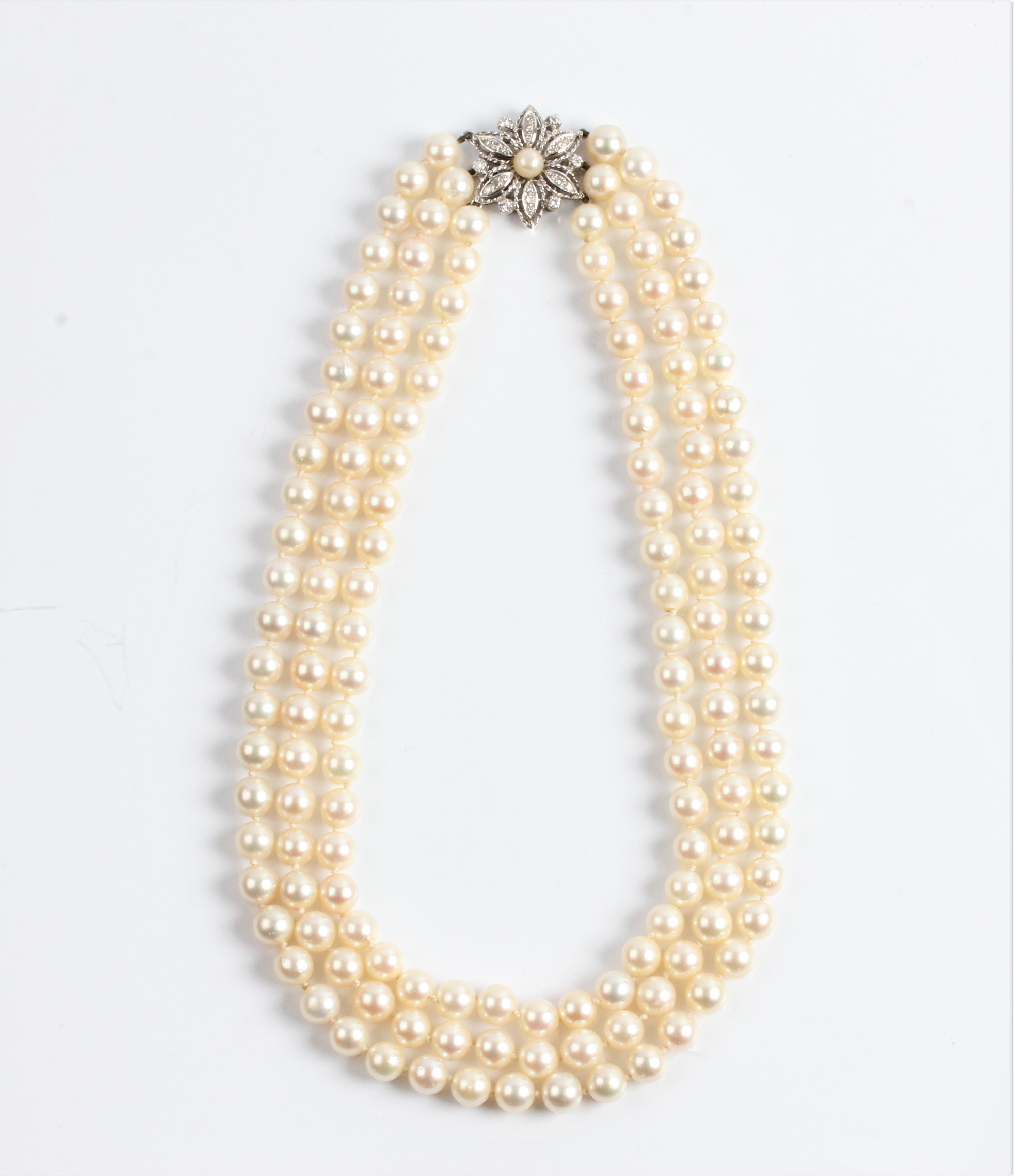 A three row string of cultured pearls with diamond flower design clasp, pearls measure approx.