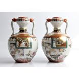 A pair of Japanese two handled vases, decorated with floral and bird patterns with court and dancing