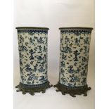 A pair of blue and white umbrella stands with French hunting scenes to bodies and bronze details