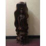 A 20th century large one piece wood carved Buddha with dragon and lotus flowers to base, height