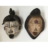 Two West African tribal face masks, with carved hair details. IMPORTANT: Online viewing and