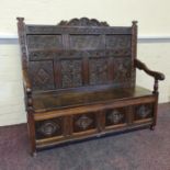 An 18th century oak monk’s bench with carved panel back and front. IMPORTANT: Online viewing and