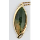 An oval green hardstone pendant, set with a central marquise cabochon surrounded by open metalwork