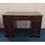 A reproduction mahogany desk with leather insert top. IMPORTANT: Online viewing and bidding only.