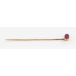 A garnet set stick pin, unmarked yellow metal, in fitted box. IMPORTANT: Online viewing and