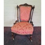 A Victorian walnut nursing pink upholstered chair. IMPORTANT: Online viewing and bidding only.