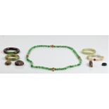 A collection of carved green hardstone jewellery, to include three bangles, a ring, a bead necklace,