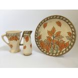 A Crown Ducal Charlotte Rhead 4921 Golden Leaves pattern charger, diameter 32cm, with two jugs,