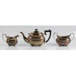 A three piece silver tea set, comprising a tea pot, a sugar bowl and a milk jug, all with gadrooning
