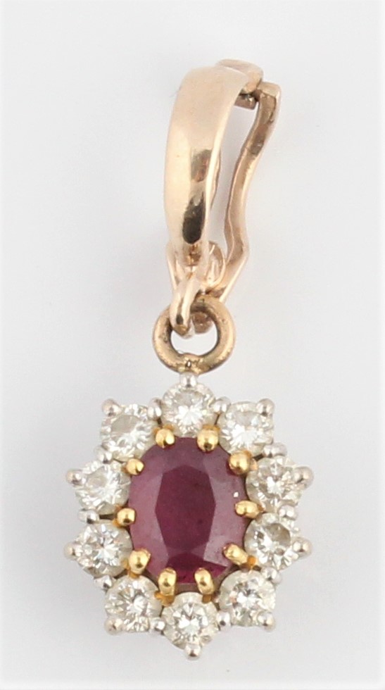 A ruby and diamond cluster pendant, centrally set with an oval cut ruby, measuring approx. 6x5mm,