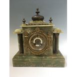 A French onyx cased mantel clock with brass column, finial and decorative detail surrounding face,