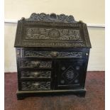 An oak carved bureau with fitted interior and green man carved handles. IMPORTANT: Online viewing