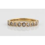 A hallmarked 9ct yellow gold diamond half eternity ring, bezel set with eleven round brilliant cut