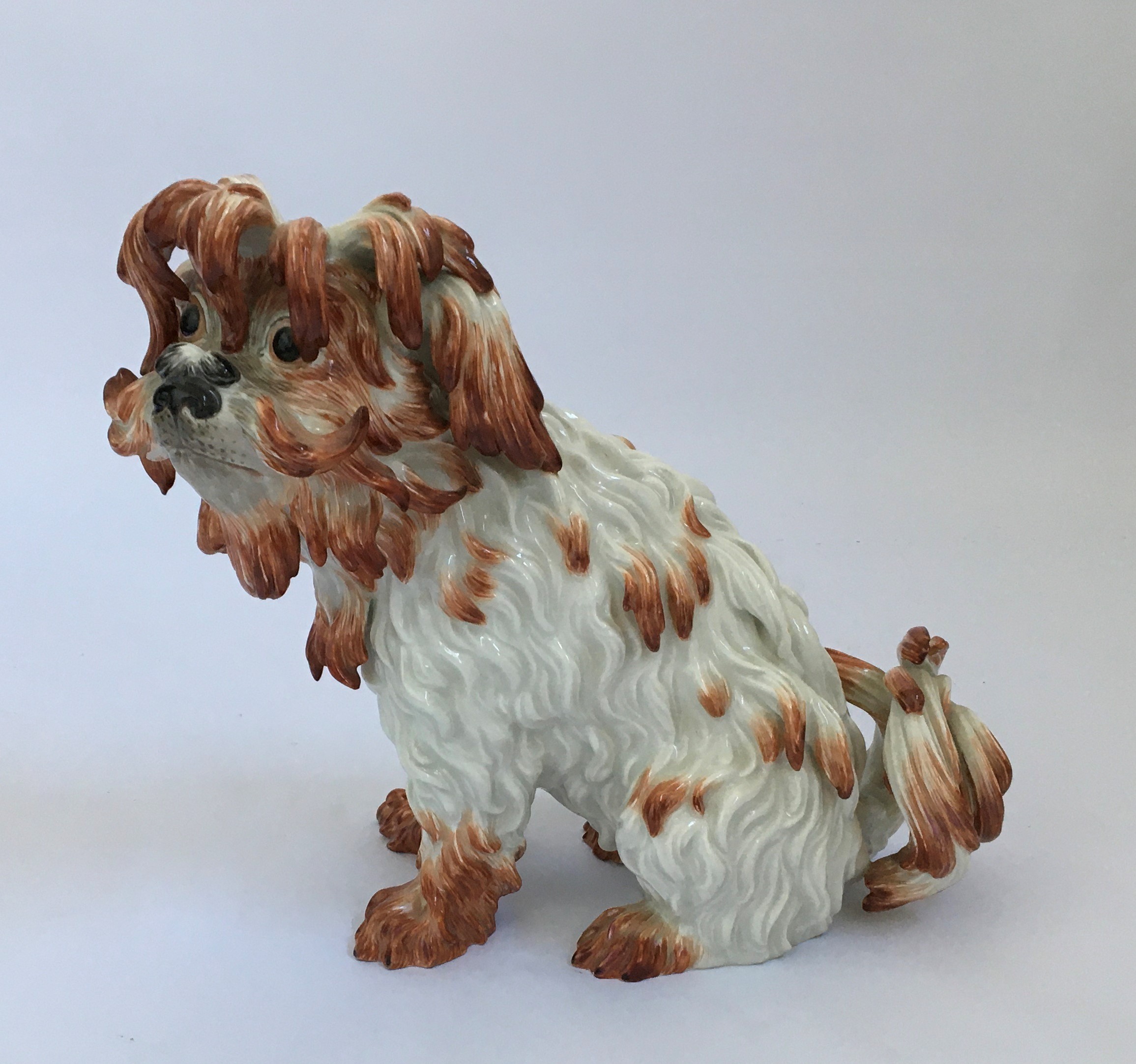 A Meissen Bolognese dog, marked with crossed swords to base, height 22cm.