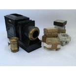 A cased magic lantern with brass adjustable lens and ten boxes of various glass slides to include