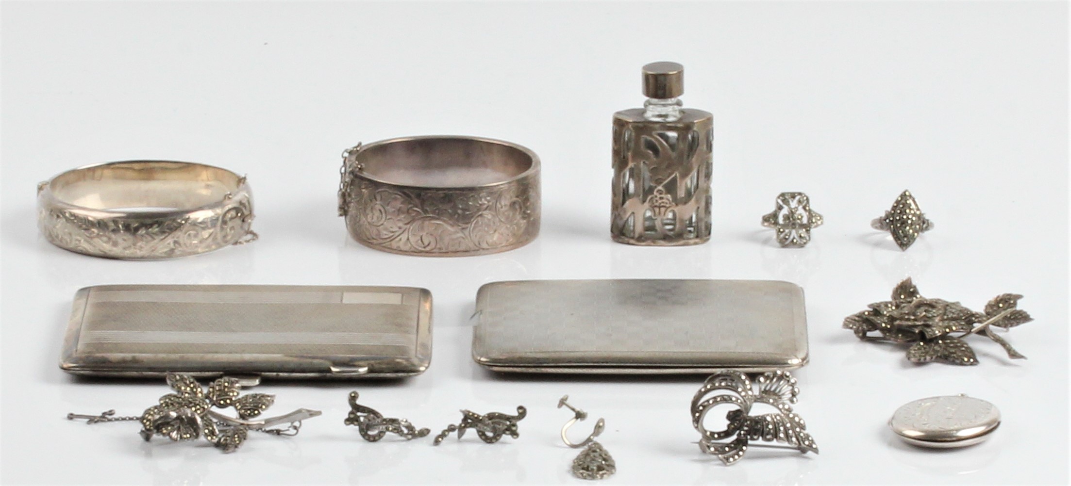 A collection of hallmarked silverware, to include a cigarette case, two hinged bangles and a locket,