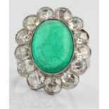 An emerald and diamond cluster ring, set with a central oval emerald cabochon, measuring approx.