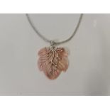 A carved leaf design pendant, featuring metalwork set with white paste stones, stamped 925, (A/F