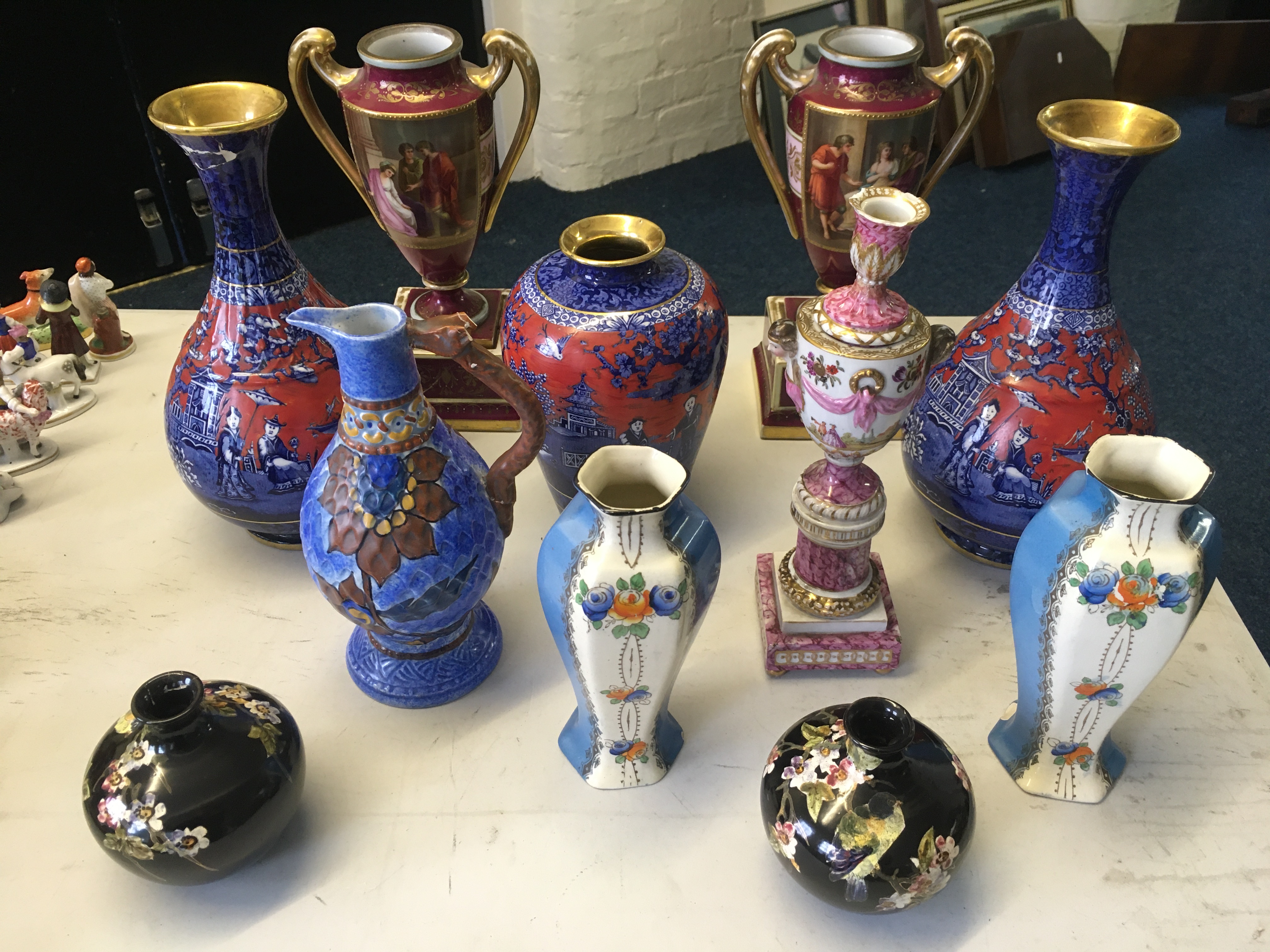 A selection of decorative items including two twin-handled vases painted with classical scenes,