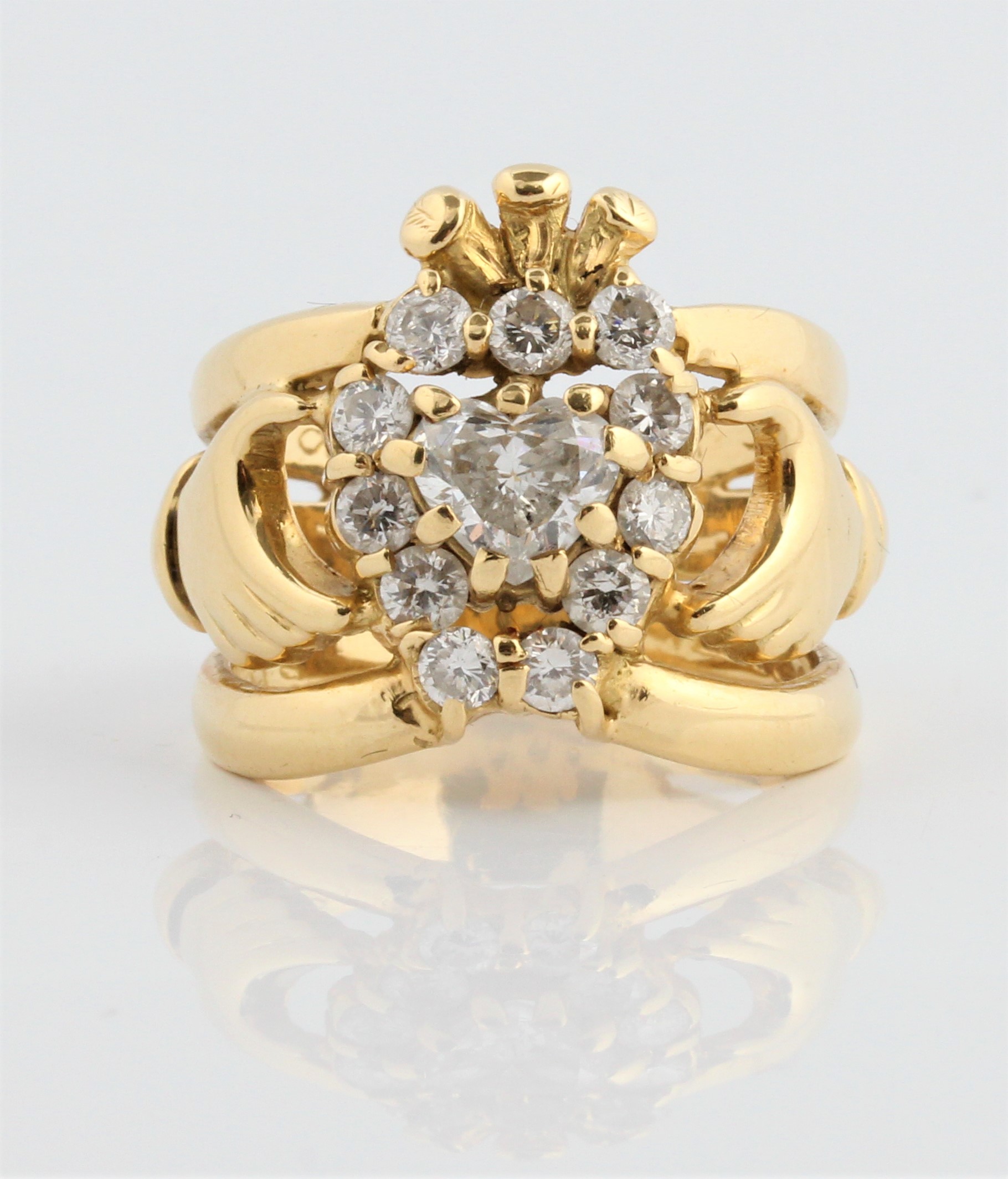 A hallmarked 18ct yellow gold diamond set Claddagh ring, set with a central heart cut diamond,