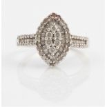 A diamond cluster ring, the marquise shaped head set with diamond accents leading onto shoulders,