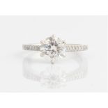 A hallmarked platinum diamond ring, set centrally with a principal round brilliant cut diamond,