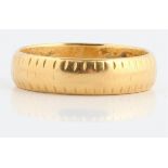 A hallmarked 18ct yellow gold patterned wedding band.