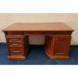 An oak American style twin pedestal desk fitted with six drawers and a swing out cupboard side