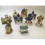 Seven building form tea light holders including Castle and church, with two other model buildings.