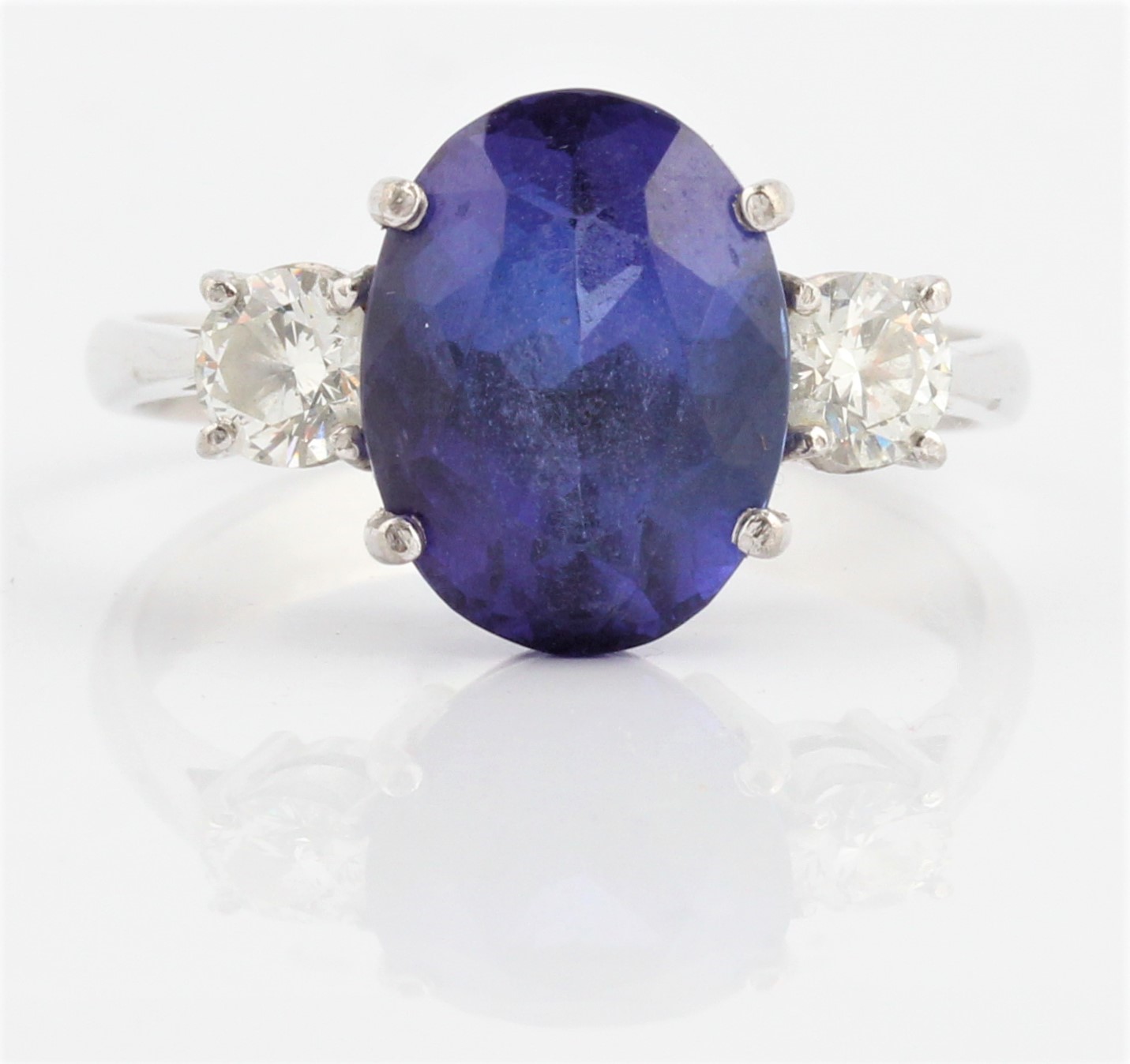 A tanzanite and diamond three stone ring, set with a central oval cut tanzanite, measuring approx.