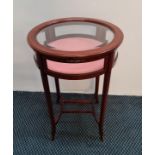 A reproduction mahogany round glazed display table on four legs. IMPORTANT: Online viewing and