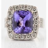 A hallmarked 18ct white gold tanzanite and diamond cluster ring, set with a cushion mixed cut