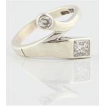 A hallmarked 9ct white gold two stone diamond cross over design ring, set with a princess cut