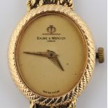 A ladies Baume & Mercier wrist watch, featuring a plain gold-tone dial with textured metalwork