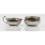 A Victorian silver milk jug and sugar bowl, of squat form with gadrooned design to lower body,