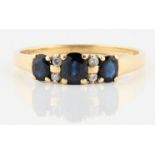 A hallmarked 18ct yellow gold sapphire and diamond ring, set with three graduated oval cut sapphires