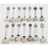 A collection of 14 various hallmarked silver tourist spoons, most featuring enamel detailing to