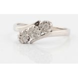 A diamond ring, set with three diamond accent clusters in cross over design band, stamped 18k,