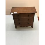 A miniature mahogany three drawer chest.