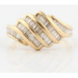 A hallmarked 14ct yellow gold diamond dress ring, the panelled design set with baguette and