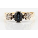 A hallmarked 18ct yellow gold sapphire and diamond three stone ring, set with a central oval cut