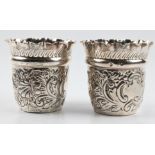 A pair of Victorian silver Mappin & Webb beakers, both of repousse scroll, foliage and shell